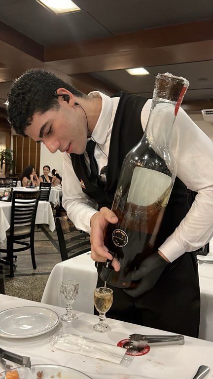 Cachaça poured from a large bottle at Churrascaria Estância