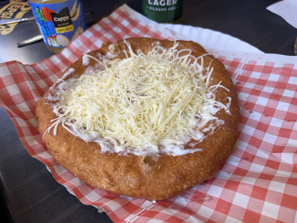 Our classic cheese-and-sour-cream lángos on checkered serving paper
