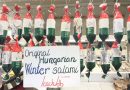László’s packaged salami beneath a Winter salami sign at a Budapest market stall