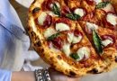 Pizza topped with sliced charcuterie, cheese and basil