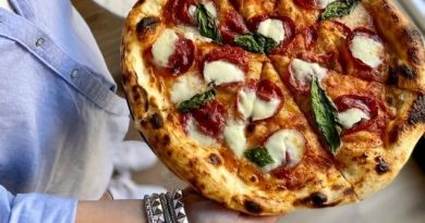 Pizza topped with sliced charcuterie, cheese and basil