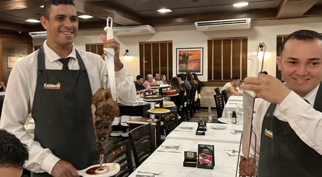 Waiters serving meat on skewers at Churrascaria Estância’s Catumbi branch in São Paulo